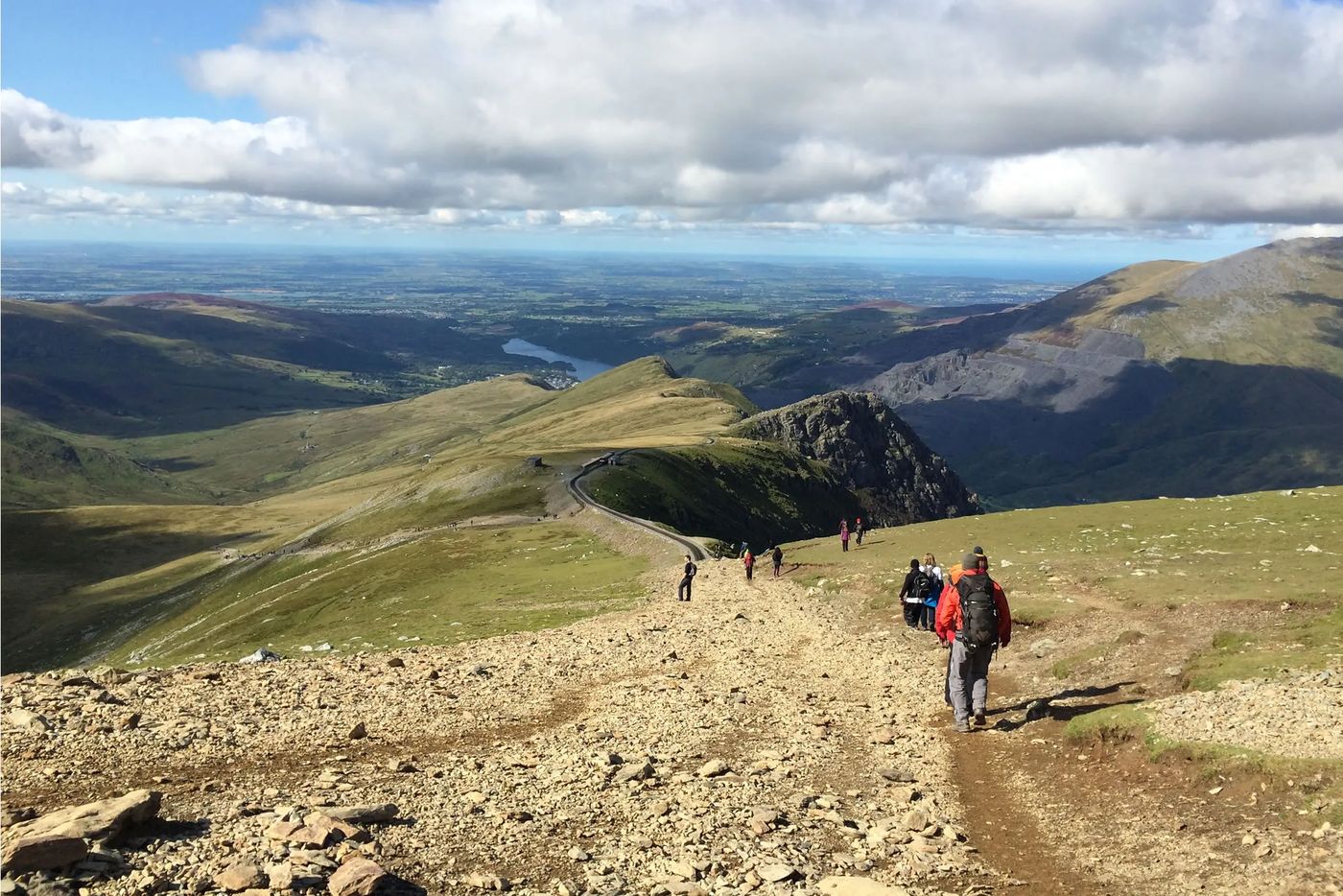 Hikers on the Llanberis Path high on Snowdon, with the valley far below